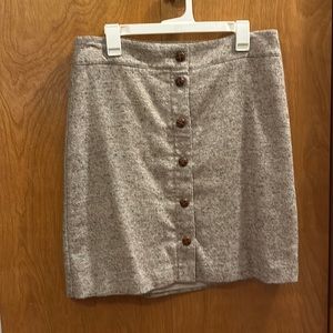 Hits at knee. Button up front skirt.